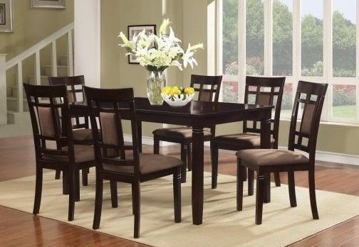 A dining room table and chairs with a vase of flowers on it