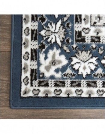 A blue and white rug is sitting on a wooden floor.