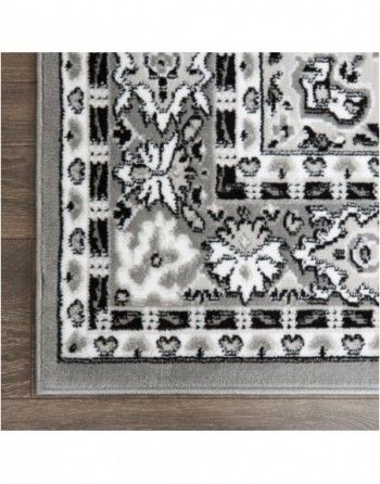A black and white rug is sitting on a wooden floor.