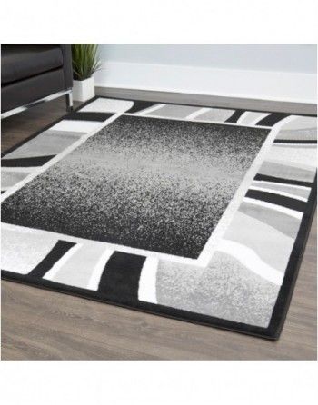 A black and white rug is sitting on a wooden floor in a living room.