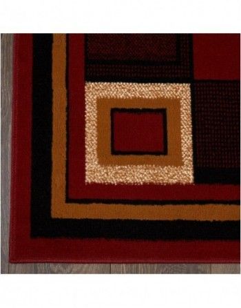 A red rug with a square in the middle is sitting on a wooden floor.