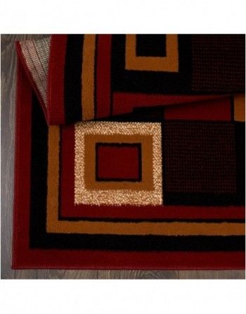 A red black and gold rug with a square in the middle