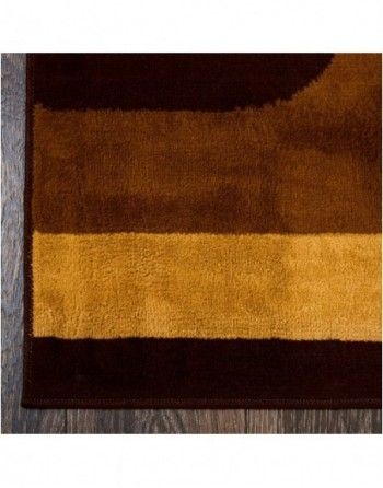 A close up of a brown and yellow rug on a wooden floor.