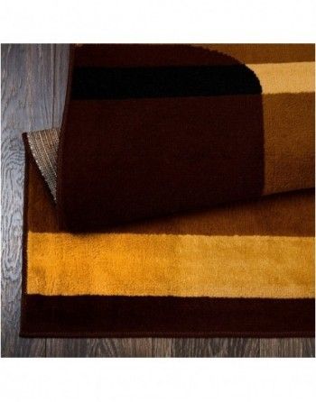 A brown and yellow rug is laying on a wooden floor.