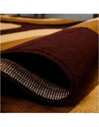 A brown and tan rug is rolled up on a white surface