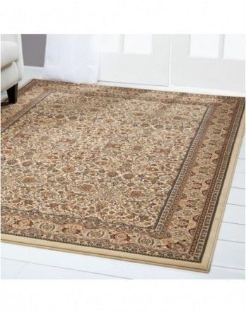 A rug is sitting on the floor in a living room next to a couch.