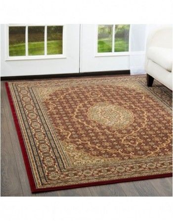 A rug is sitting on a wooden floor in a living room next to a couch.