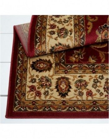 A red and tan rug with a floral pattern on it