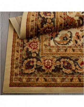 A rug with a floral pattern is rolled up on a wooden floor.