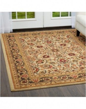 A rug is on the floor in a living room next to a couch.