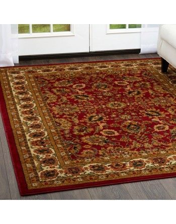 A red rug is sitting on a wooden floor in a living room.