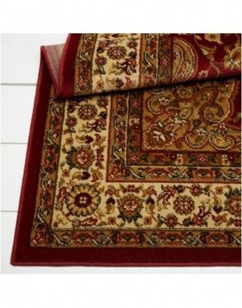 A red and tan rug with a floral pattern on it