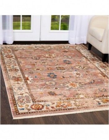 A rug is sitting on a wooden floor in a living room next to a couch.