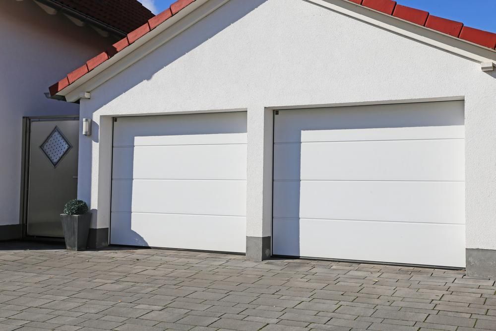Two White Garage Doors With A Red Roof — Mick’s Garage Doors In Alice River, QLD