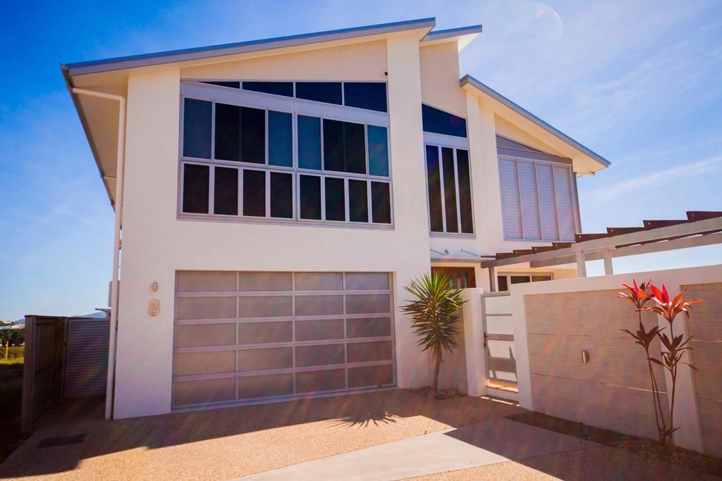 A Large White House With A Stainless Steel Garage Door — Mick’s Garage Doors In Alice River, QLD