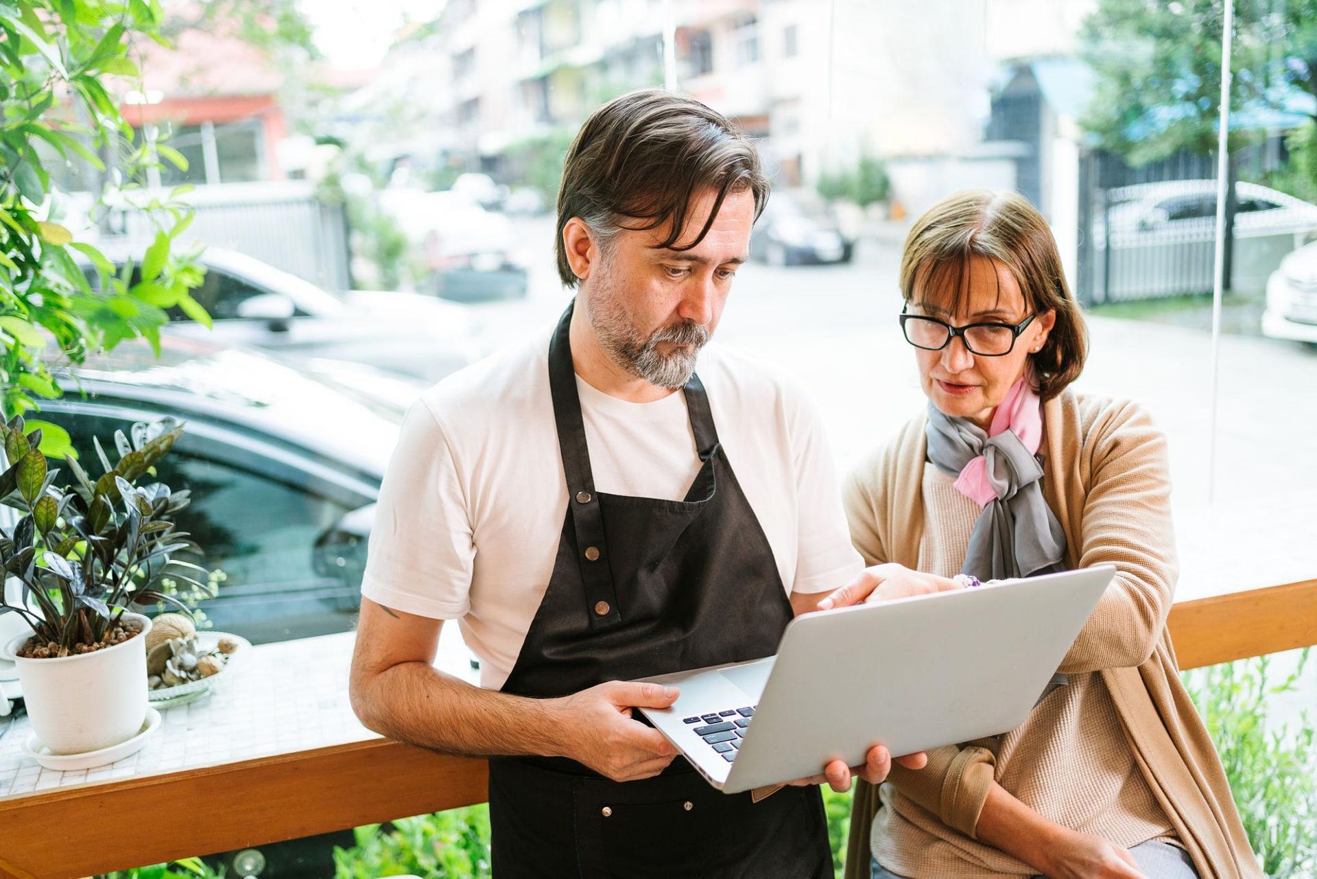A business owner and consultant reviewing operational information together on a laptop