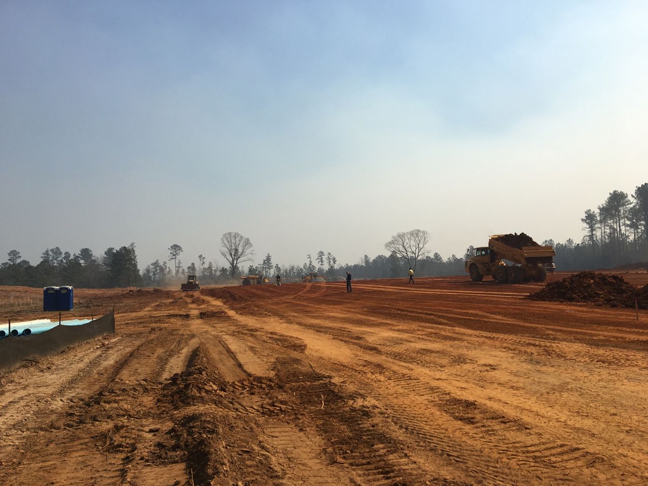 A large truck is driving down a dirt road.