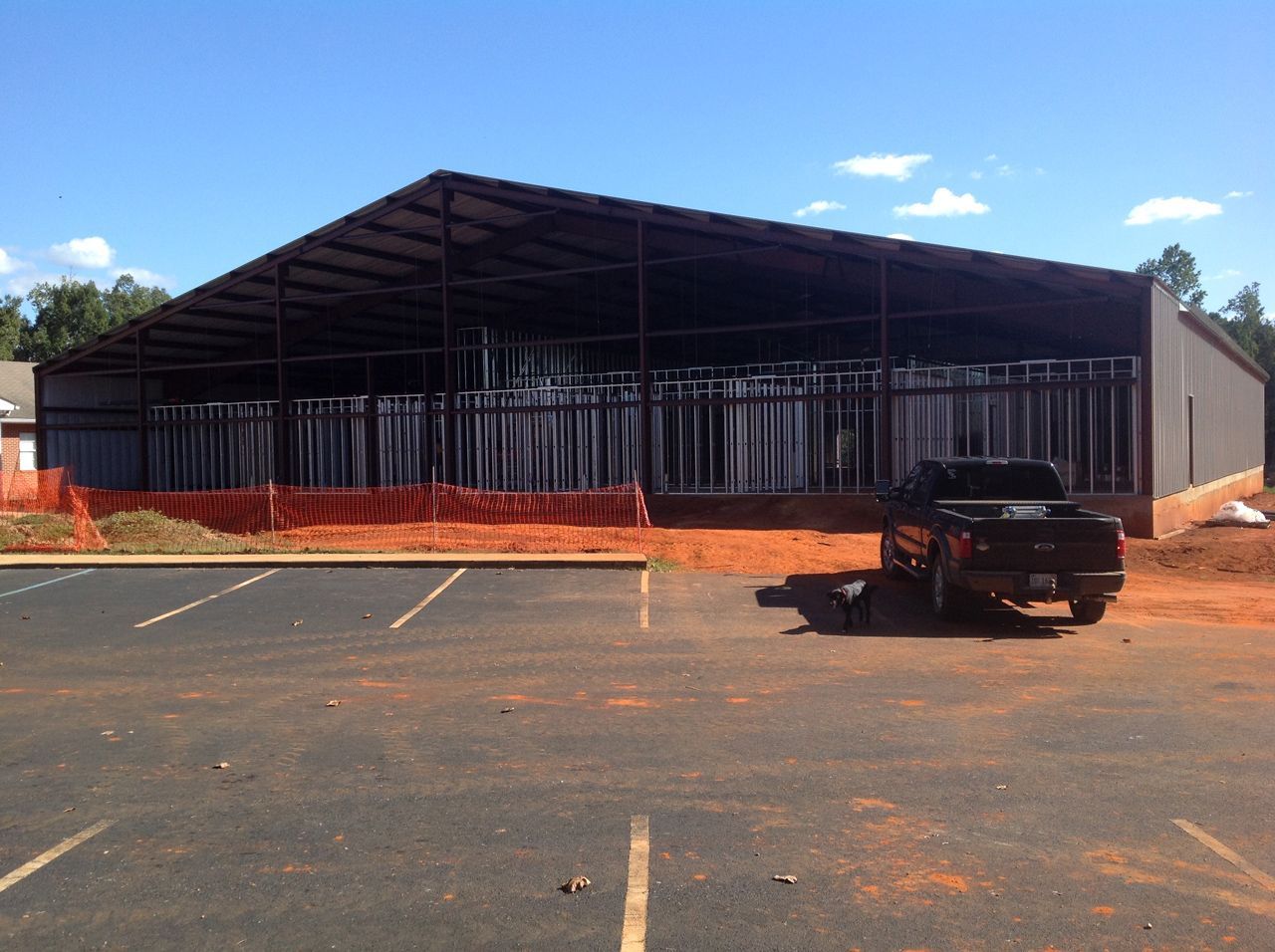 A truck is parked in front of a building under construction.