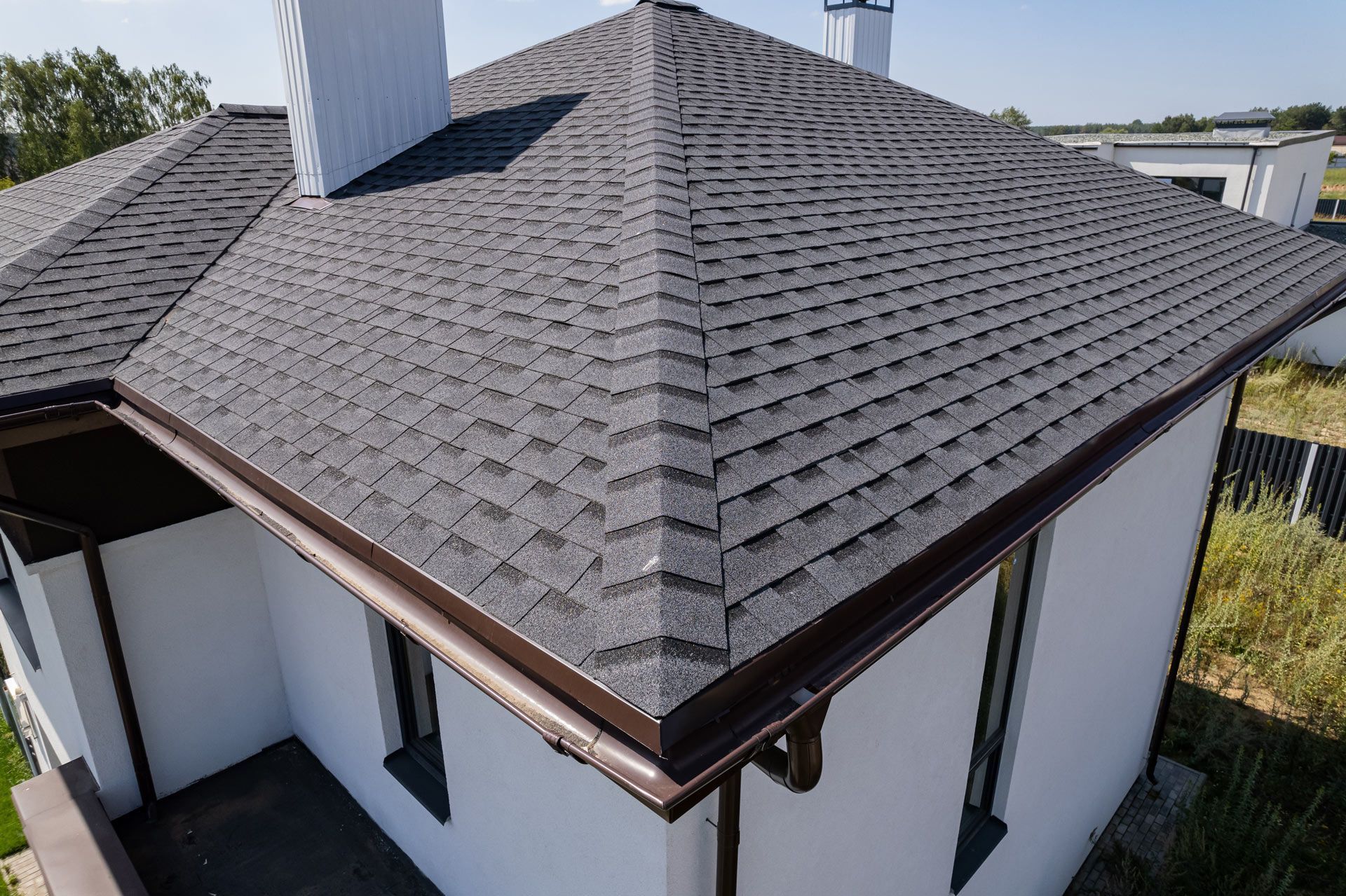 A white house with a gray roof and a chimney