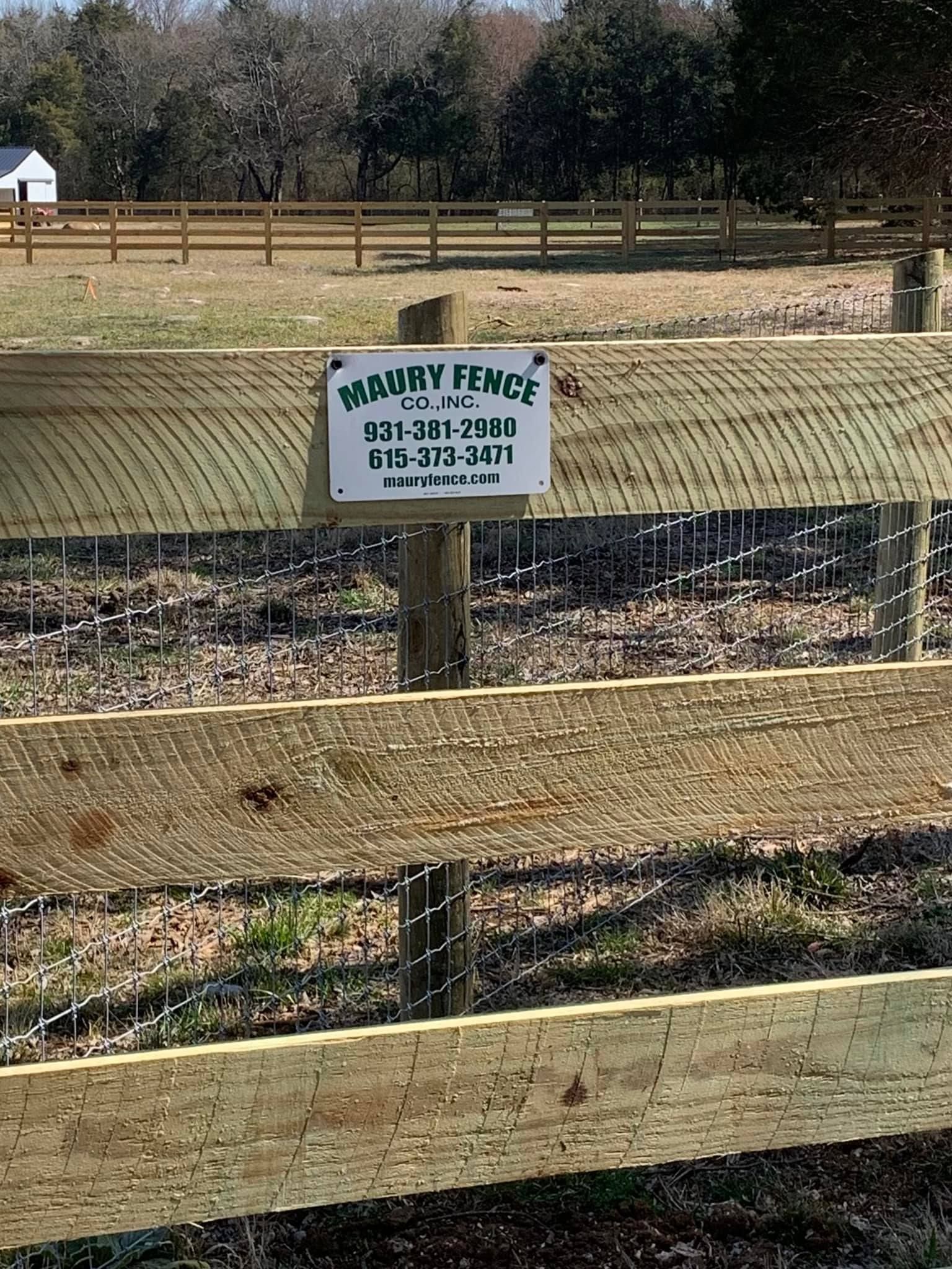 Sign for Danny Fence Co. on a wooden fence, outdoors.