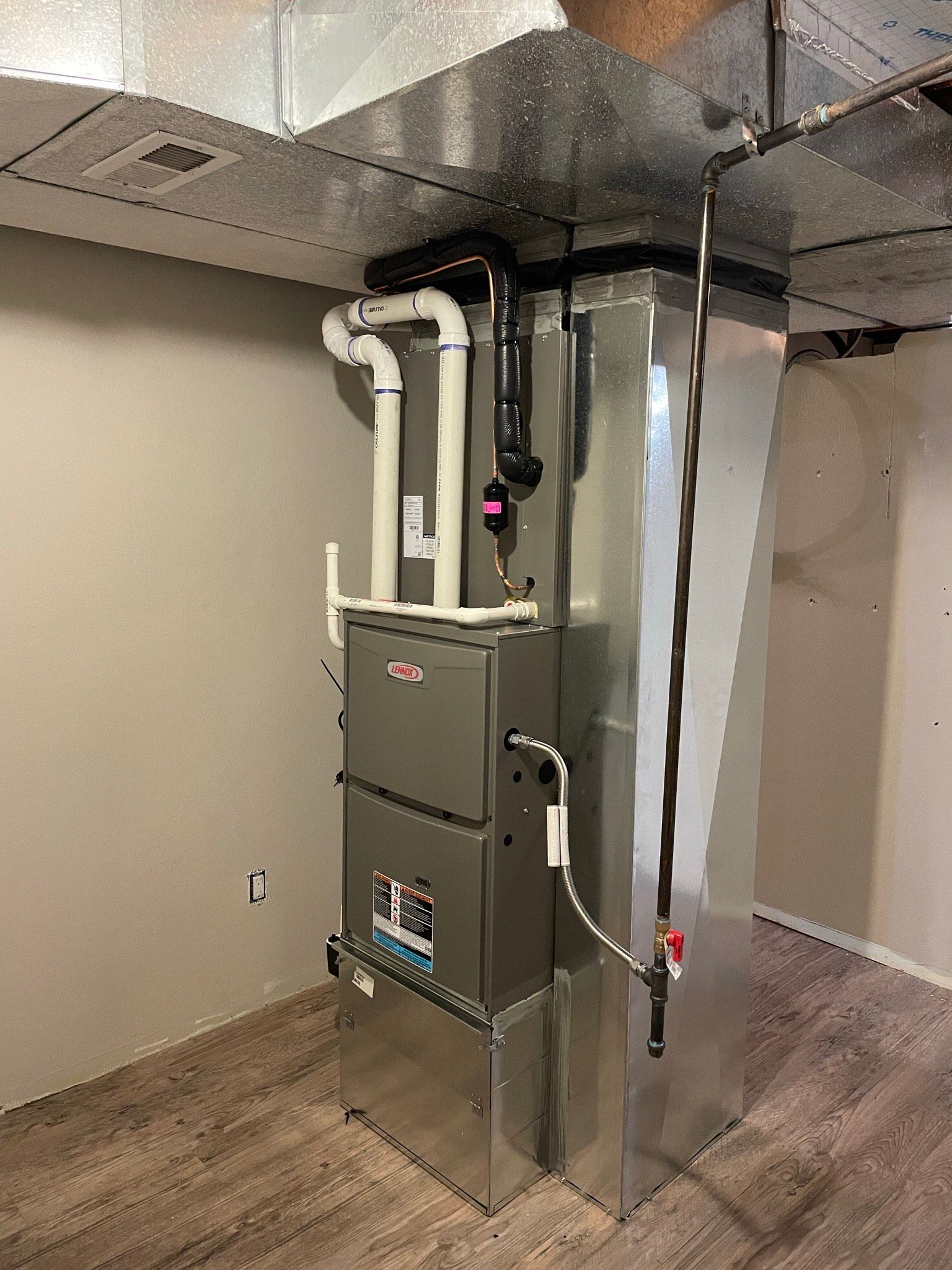 A stainless steel air conditioner is installed in a basement.