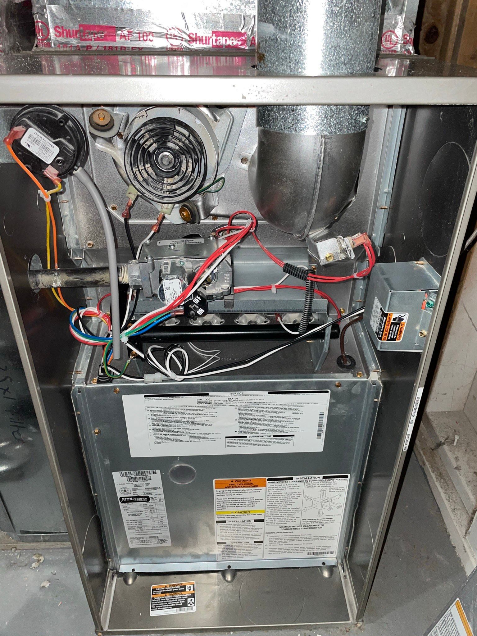 The inside of a furnace with a lot of wires coming out of it.