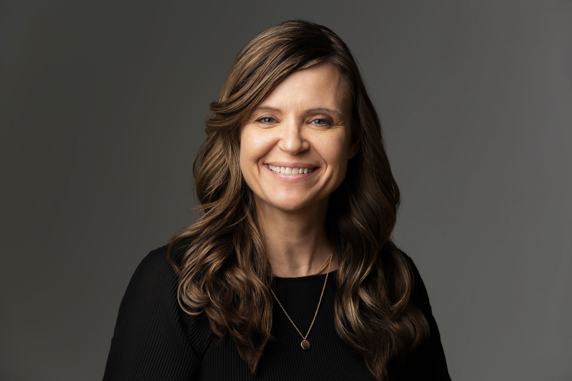 a woman is sitting in a chair in front of a brick wall .