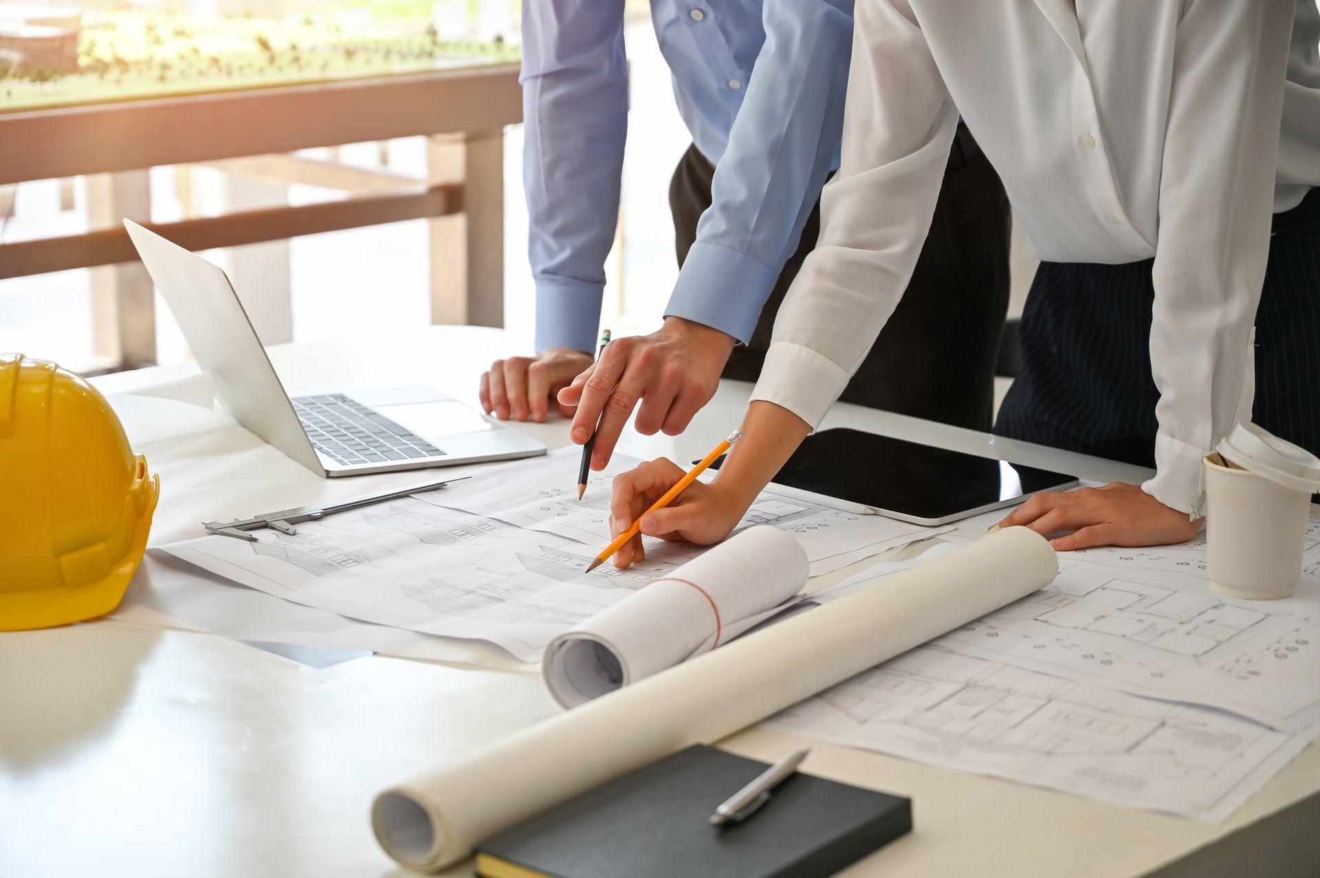 a group of people are looking at a blueprint on a table .