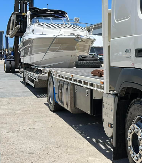 A truck is carrying a boat on the back of it