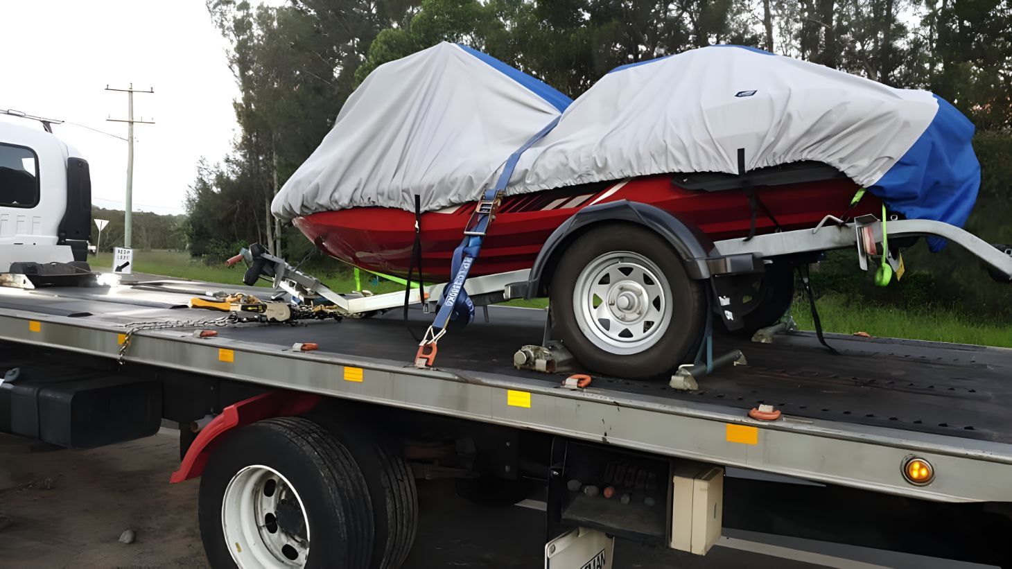 Red Boat is Sitting on Top of a Tow Truck — NCM Towing Newcastle In Broadmeadow, NSW