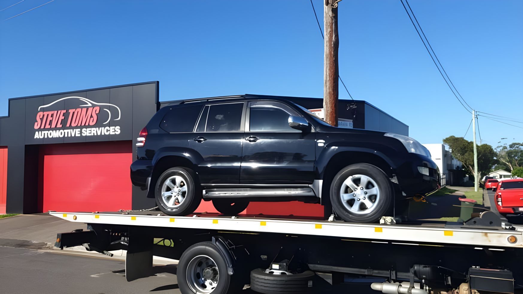 Black Suv is Sitting on Top of a Flatbed Tow Truck — NCM Towing Newcastle In Port Stephens, NSW