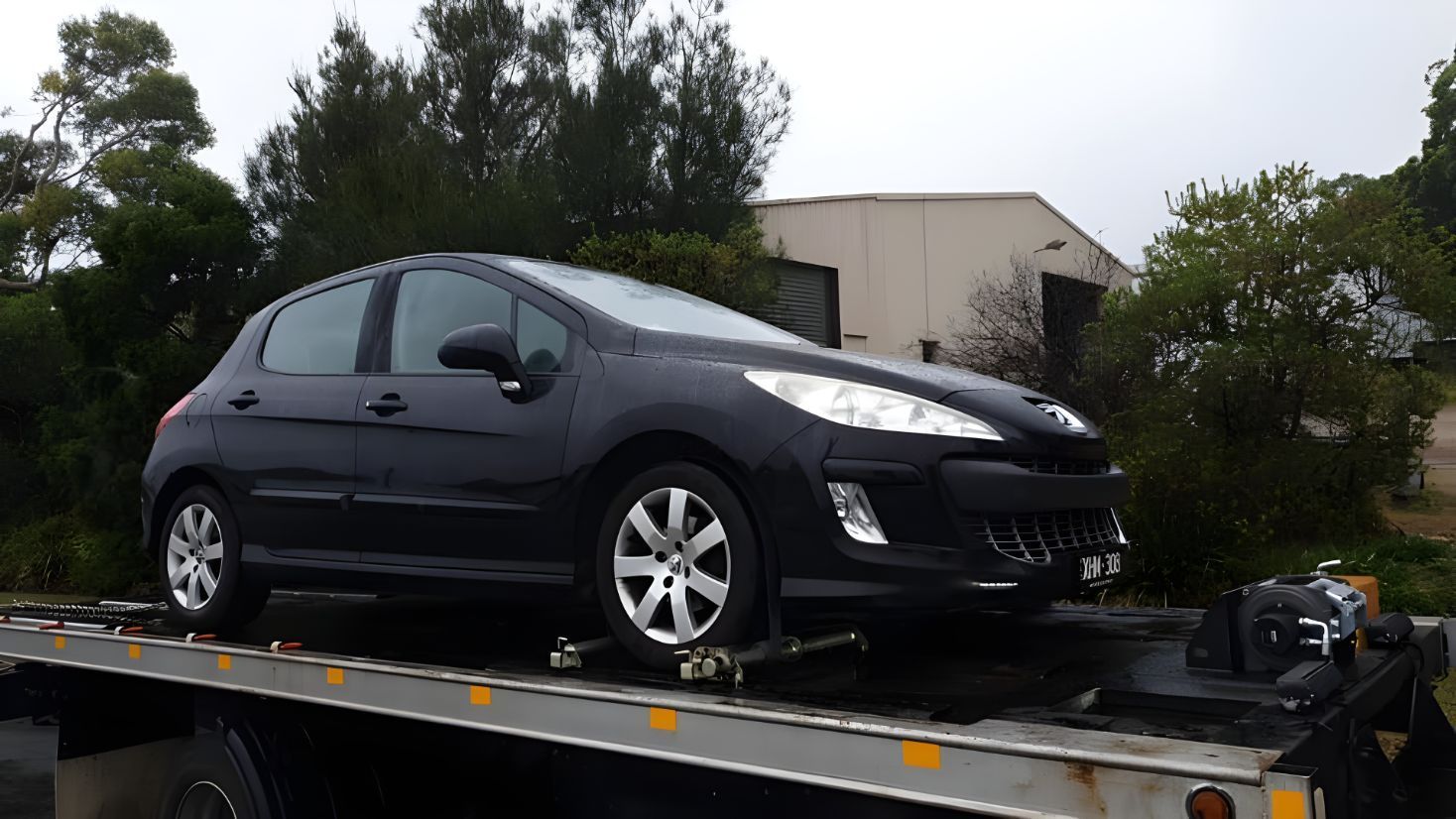 Black Car is Sitting on Top of a Tow Truck — NCM Towing Newcastle In Maitland, NSW