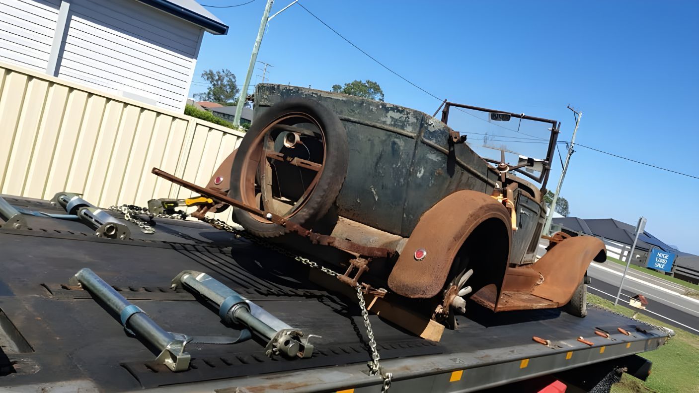 Old Car is Sitting on Top of a Tow Truck — NCM Towing Newcastle In Broadmeadow, NSW
