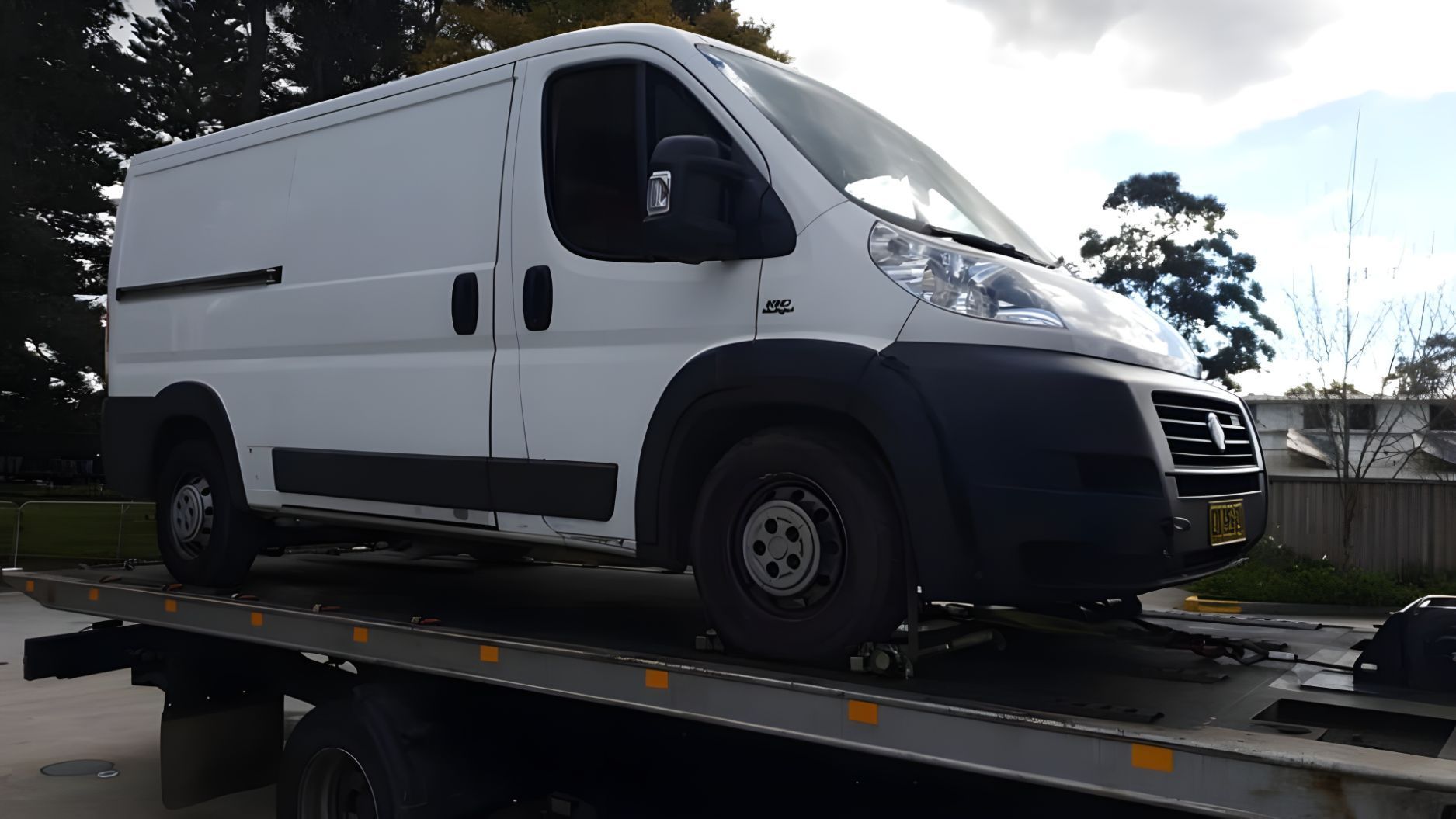 White Van is Sitting on Top of a Tow Truck — NCM Towing Newcastle In Broadmeadow, NSW