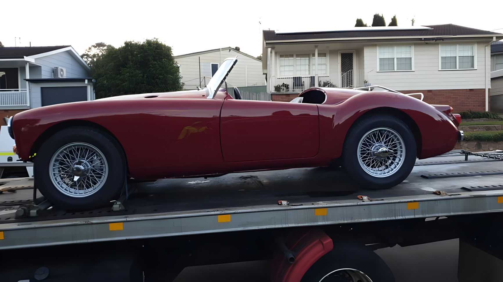 Red Sports Car is Sitting on Top of a Tow Truck — NCM Towing Newcastle In Toronto, NSW