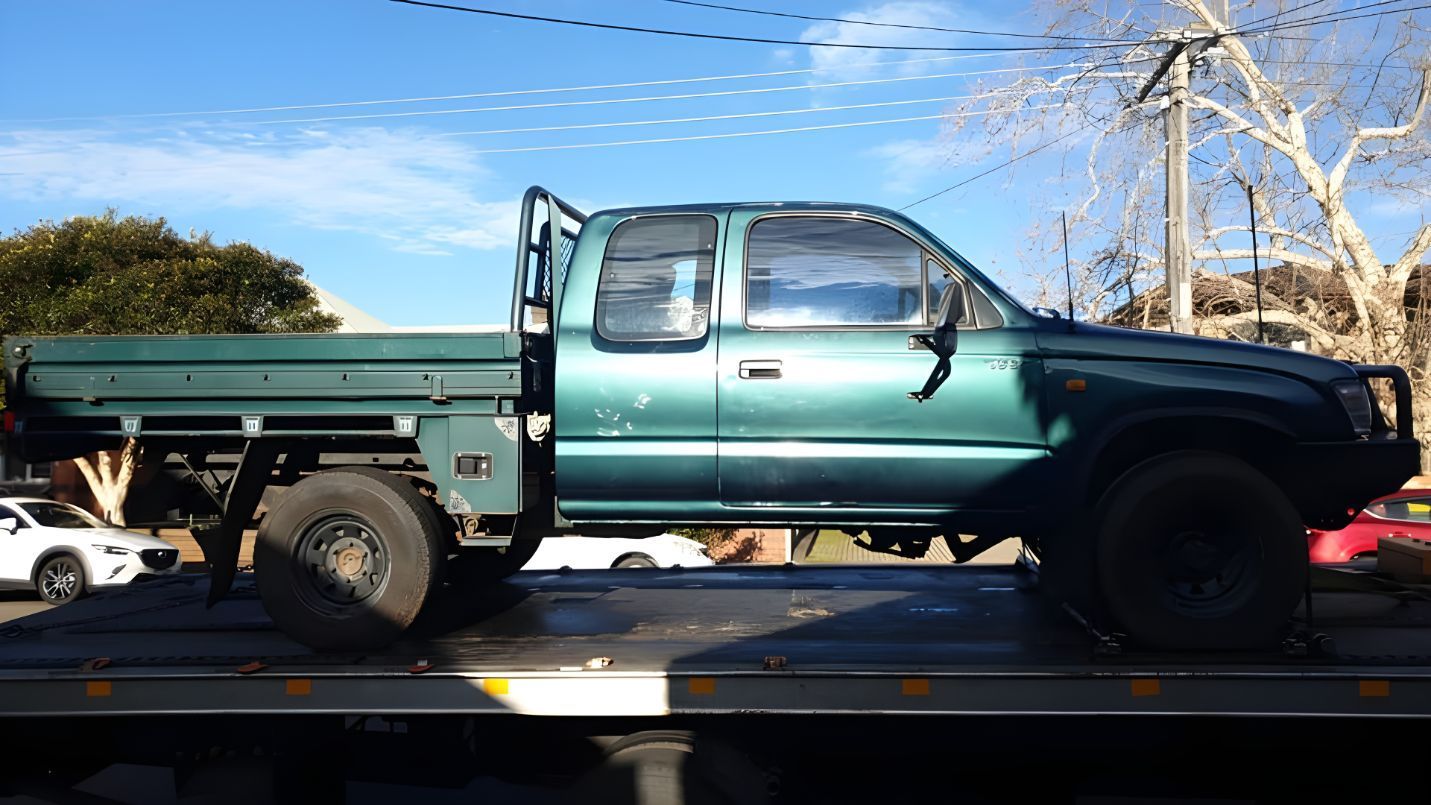 Green Truck is Sitting on Top of a Tow Truck — NCM Towing Newcastle In Sydney, NSW