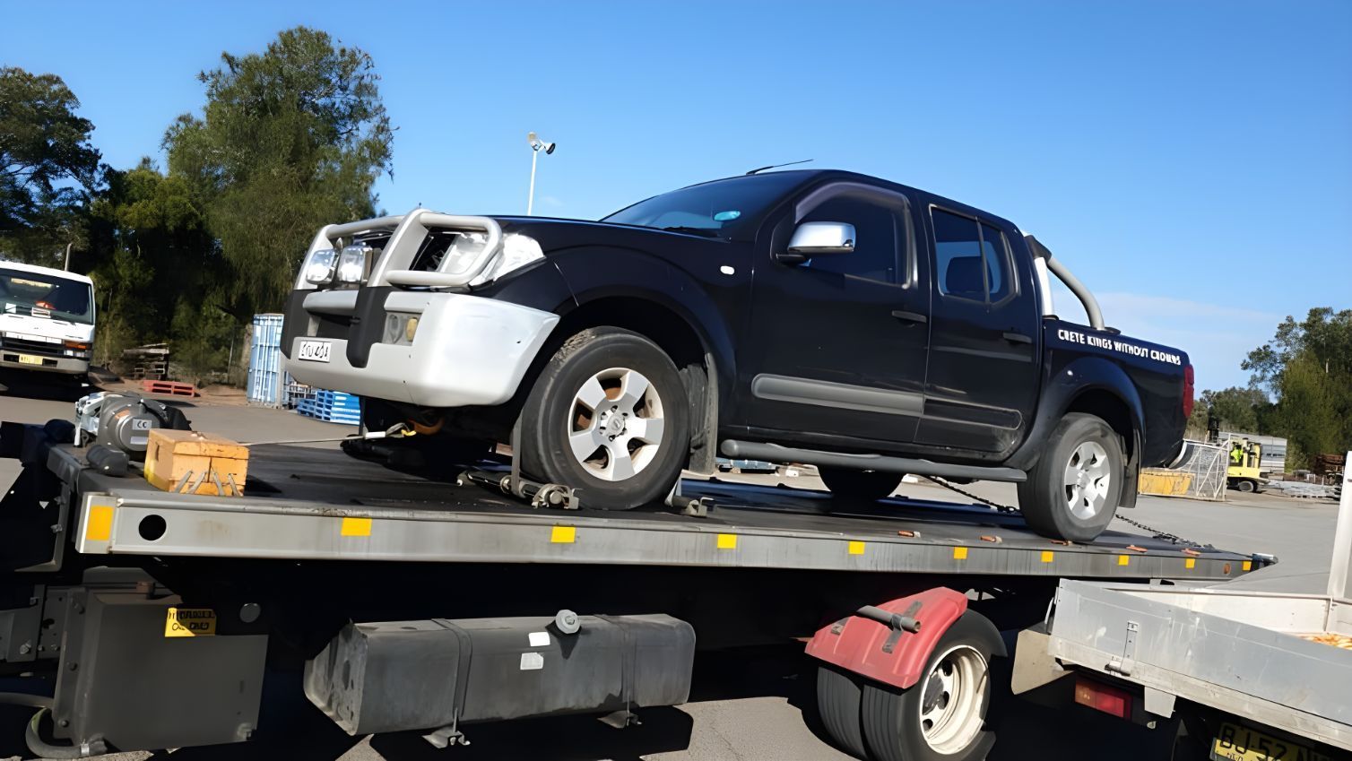 Black Truck is Sitting on Top of a Tow Truck — NCM Towing Newcastle In Newcastle, NSW
