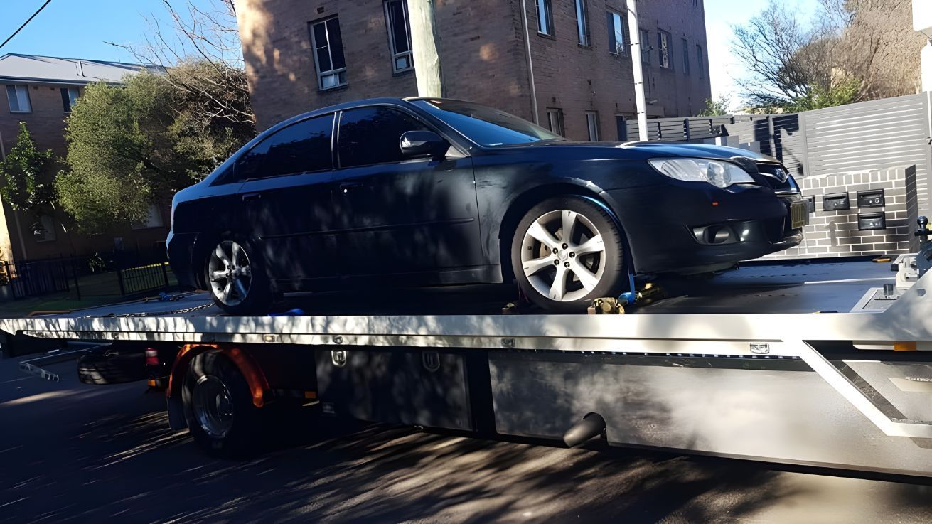 Black Car is Sitting on Top of a Tow Truck — NCM Towing Newcastle In Newcastle, NSW
