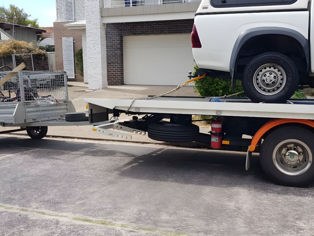 White Truck is Being Towed by a Tow Truck — NCM Towing Newcastle In Broadmeadow, NSW