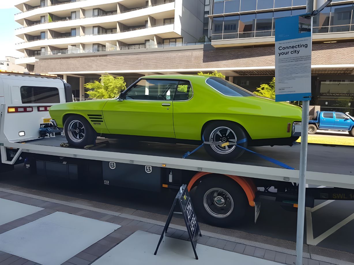 Green Car is Sitting on Top of a Tow Truck — NCM Towing Newcastle In Broadmeadow, NSW