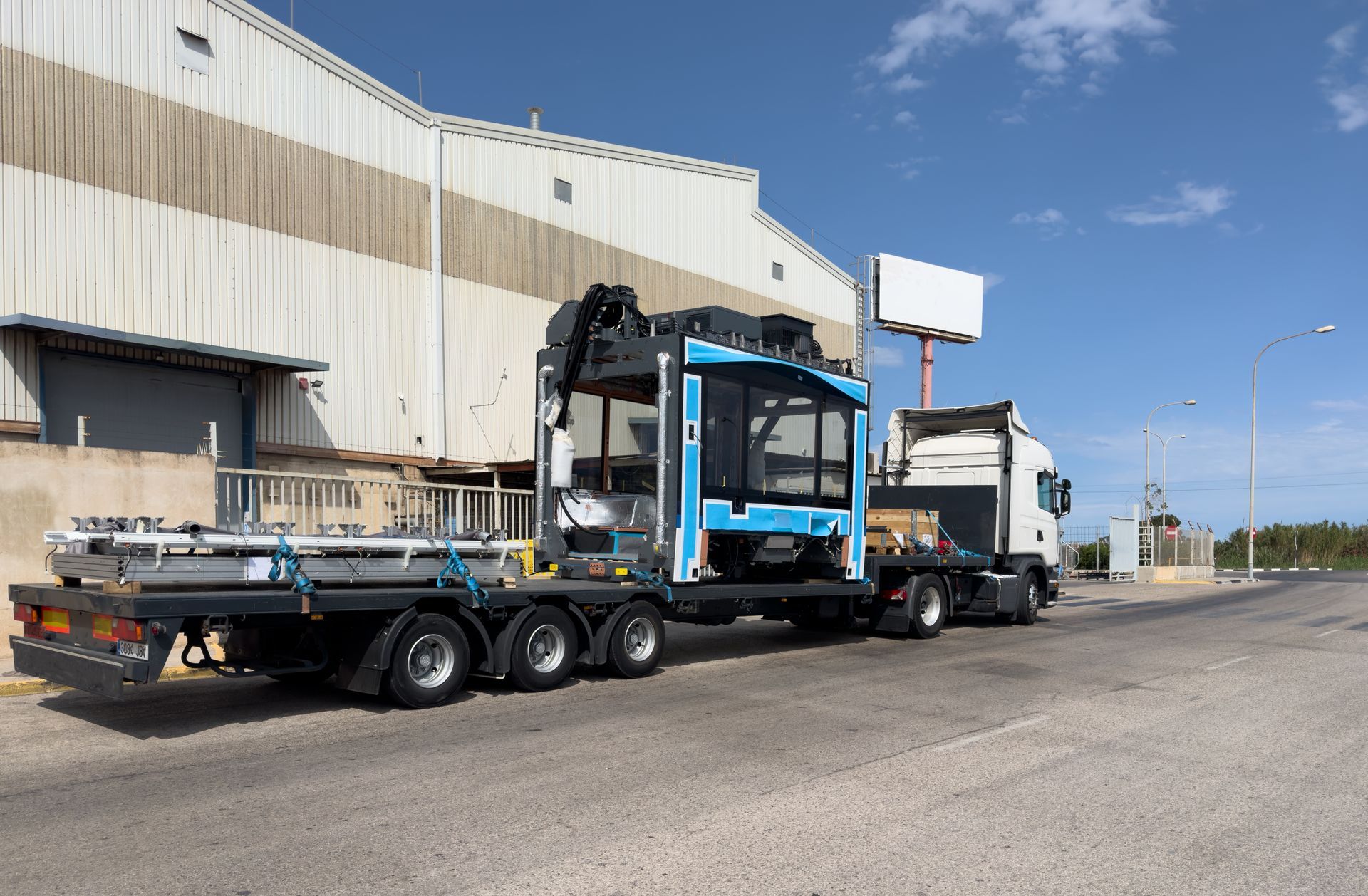 Truck With a Blue Crane Carrying Equipment Parked Outside a Building — NCM Towing Newcastle In Maitland, NSW