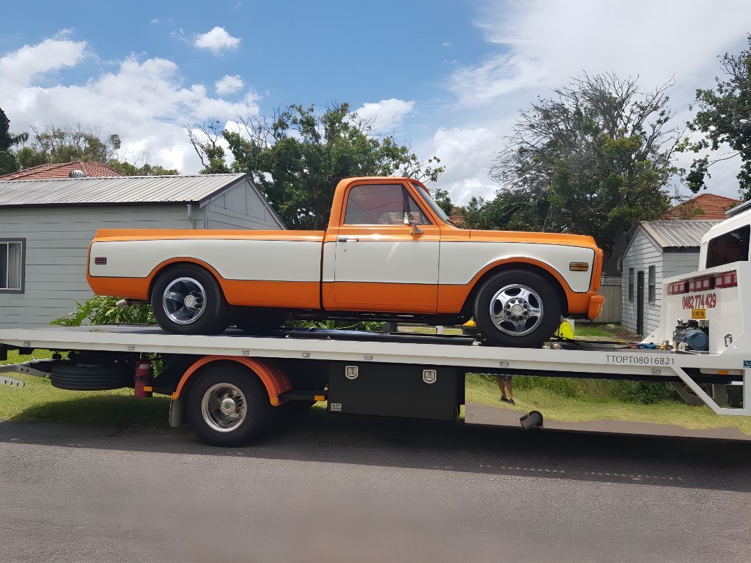 Orange and White Truck is Sitting on Top of a Tow Truck — NCM Towing Newcastle In Hunter Valley, NSW