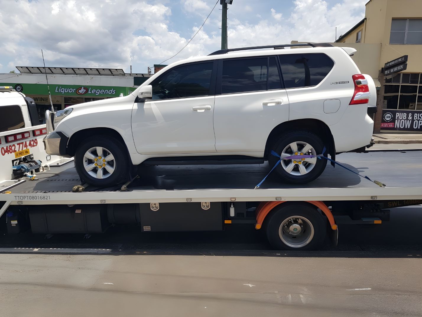 White Suv is Sitting on Top of a Tow Truck — NCM Towing Newcastle In Broadmeadow, NSW