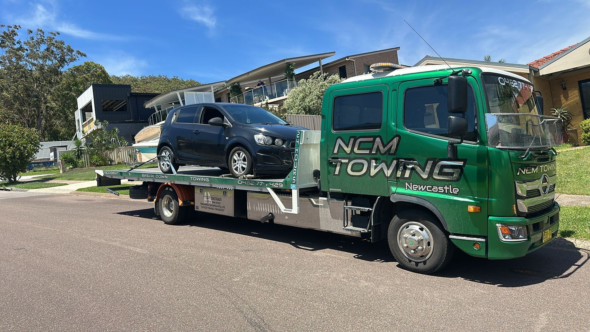 Black Car is Sitting on Top of a Tow Truck — NCM Towing Newcastle In Broadmeadow, NSW