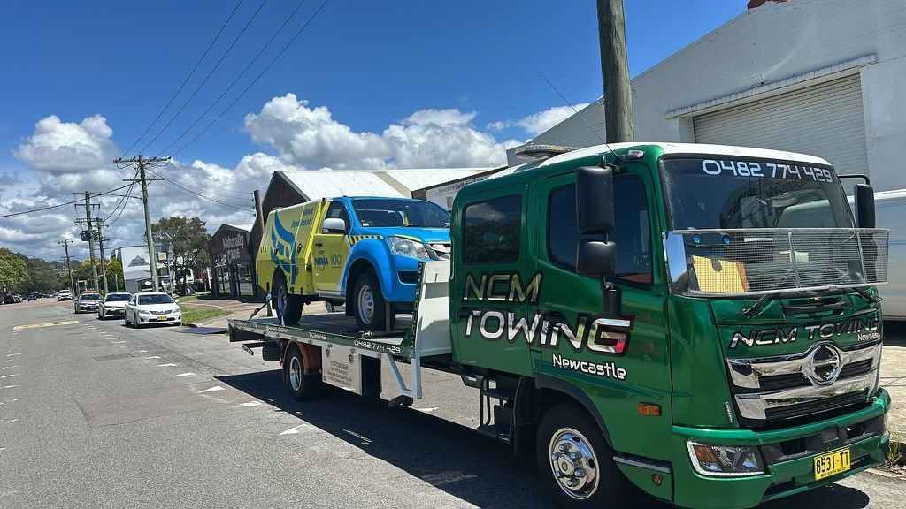 Yellow and Blue Van Being Towed on Bed of a Tow Truck — NCM Towing Newcastle In Broadmeadow, NSW