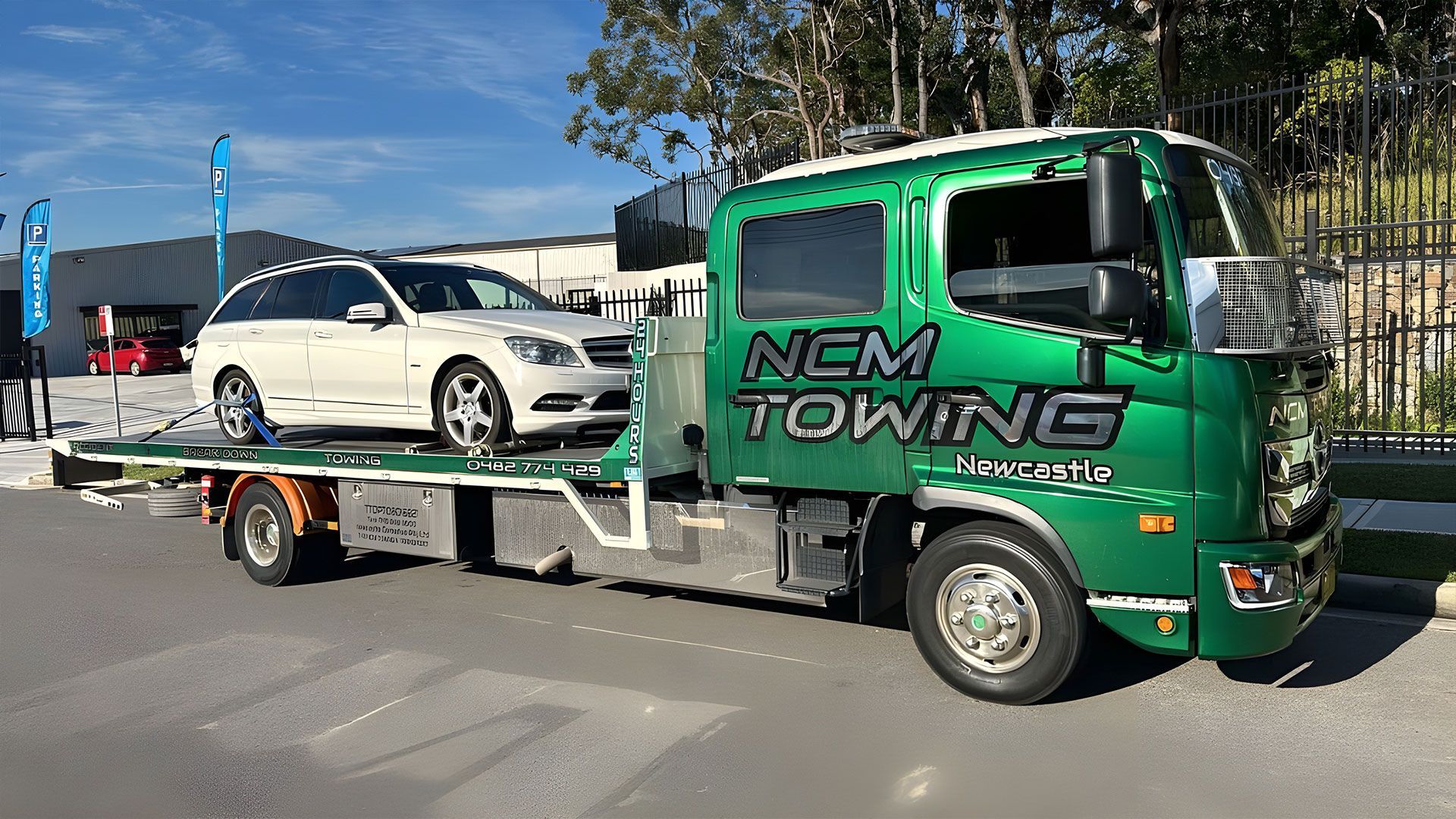 White Car is Sitting on Top of a Tow Truck — NCM Towing Newcastle In Broadmeadow, NSW