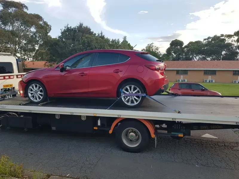 Red Car is Sitting on Top of a Tow Truck — NCM Towing Newcastle In Maitland, NSW