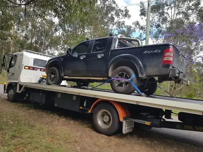 Black Truck is Being Towed by a Tow Truck — NCM Towing Newcastle In Maitland, NSW