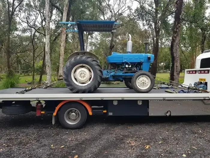 Blue Tractor is on the Back of a Tow Truck — NCM Towing Newcastle In Maitland, NSW