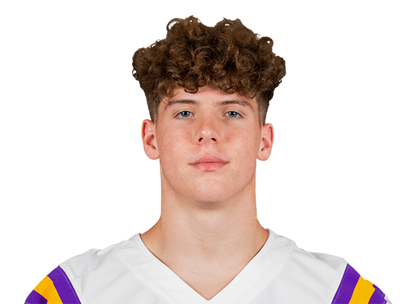 Portrait of a football player in a white jersey with purple and gold trim, looking at the camera